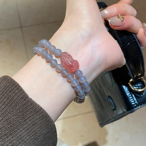 Detail of double-layer agate and strawberry crystal Pixiu bracelet on a wrist