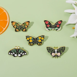 Set of five vintage butterfly and moth enamel pins with floral and geometric patterns