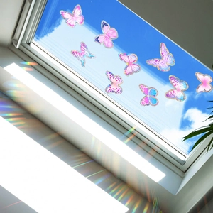 Close-up of butterfly window decals casting vibrant rainbow light reflections on a wall