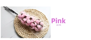 Detailed view of artificial pink cotton flower bouquet on a round rustic woven mat