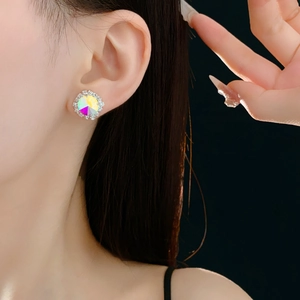 Close-up of model wearing silver round stud earring with rainbow gemstone and pavé diamonds