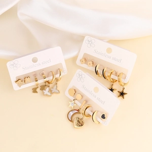 Gold stainless steel earring set featuring butterfly, moon, and star shapes on silk