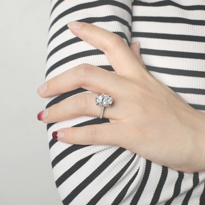 Macro side view of a luxury oval-cut zircon ring with 925 silver pave-set band on a hand