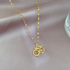 Detail of gold cherry pendant with zircon stones on a gray silk background