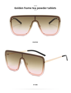 Detail of oversized gold-frame sunglasses featuring stylish tea-pink gradient lenses