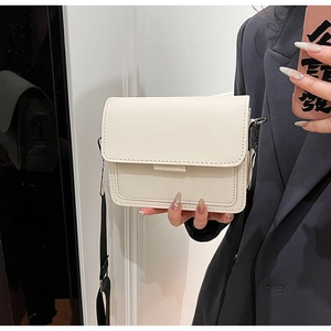 Off-white crossbody bag with wide black strap shown on model for a trendy casual style