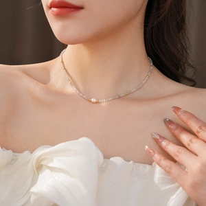 Detailed view of freshwater pearl necklace with gray beads on model's neck