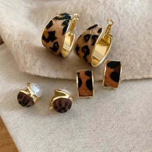Leopard print faux horsehair earrings set with gold hoops and pearl studs in warm tones