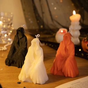 Halloween grim reaper scented candles in black white and orange on a wooden table