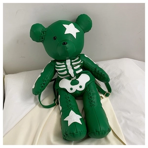 Detail of green teddy bear backpack showing lychee grain PU leather and star appliques