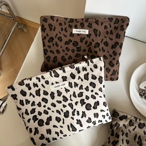 Détail de pochettes en velours côtelé à motif léopard avec fermeture éclair en métal