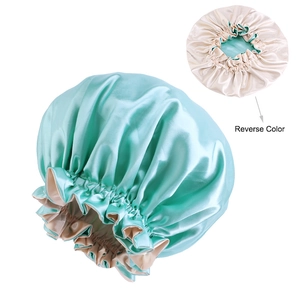 Close-up of dual-layer satin sleep bonnet with mint green and beige reversible design