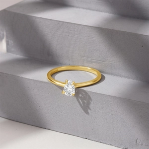 Close-up of S925 silver stamp on teardrop gem ring with gold finish and white stone