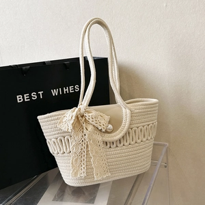 Minimalist woven straw tote bag with lace bow and pearl button for summer beach travel