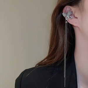 Close-up of sparkling zircon butterfly ear cuff with silver fringe tassel on ear