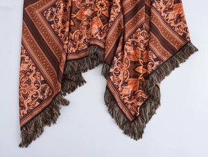Détail de l'imprimé ethnique et des glands sur une robe longue de plage bohème marron