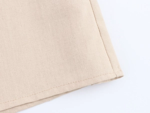 Detailed macro view of beige cotton linen fabric texture and stitching on shirt hem