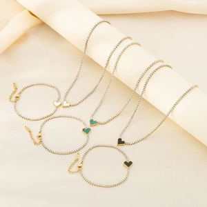 Detail view of heart pendant necklaces and bracelets in gold with colorful stone inlays