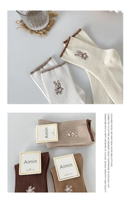 Close-up of combed cotton socks featuring cute rabbit embroidery in earthy tones
