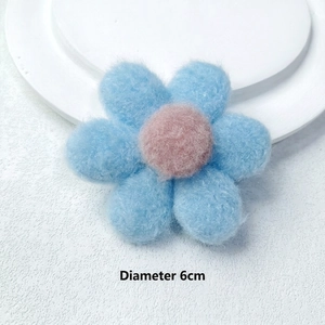 Detail of 6cm plush blue flower accessory with pink core for clothing and hair decor