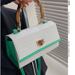 Retro crocodile pattern handbag with bamboo handle and green side panels in a city style