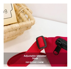 Detail of adjustable red nylon shoulder strap and black buckle on kids crossbody bag