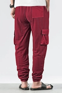 Detail of red cargo pants showing textured grid fabric and elastic drawstring waistband