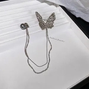 Elegant butterfly chain brooch with grey pearl and tassel charms on white tray