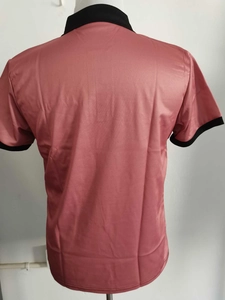 Rear view of a men's polo shirt in dusty rose with black contrasting collar and cuffs