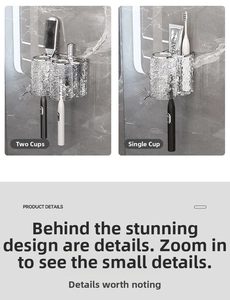 Macro view of wall-mounted metal toothbrush holder with glass cup and toothpaste slot