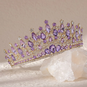 Macro shot of luxury gold crown featuring purple teardrop crystals and white rhinestones
