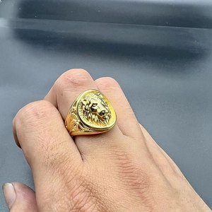Detailed close-up of a gold lion head ring showing intricate hiphop design on a finger
