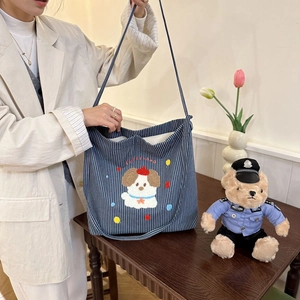Close-up of cute cartoon puppy embroidery on navy blue striped canvas tote bag