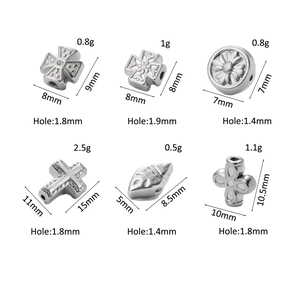 Macro view of stainless steel cross and floral spacer beads with size measurements