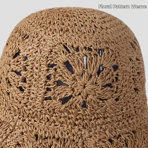 Detailed macro view showing the intricate floral crochet pattern on a foldable straw hat