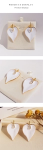 Detail of white enamel calla lily earrings with gold-plated edges in vintage style