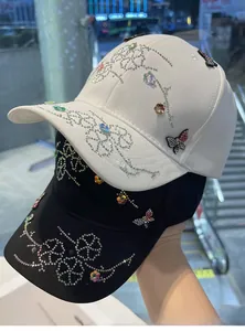 Detail of colorful butterfly and shiny rhinestones on baseball cap with floral patterns