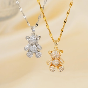 Detailed view of gold and silver bear necklaces with micro-pave crystals on silk
