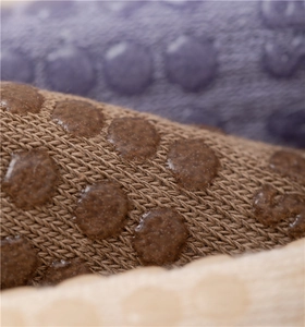 Détail des picots antidérapants en silicone sur des chaussettes de yoga en coton tricoté