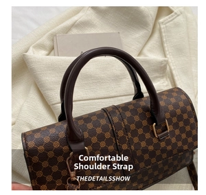 Detail of a brown vintage tote bag featuring golden clover patterns and metal buckle
