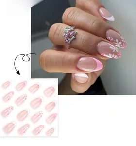 Dettaglio di unghie finte a mandorla French con fiori di ciliegio bianchi e punte rosa