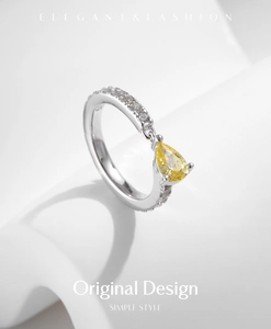 Macro shot of S925 sterling silver ring with pear-cut yellow stone and diamond accents