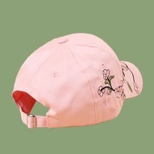 Detailed view of pink cotton baseball cap featuring delicate plum blossom floral embroidery