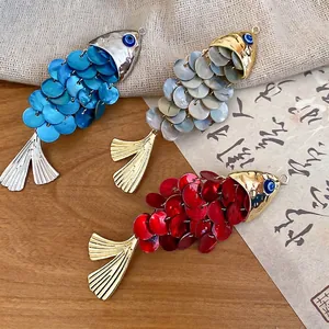 Artisan fish-shaped hair clip with shimmering sequins and blue evil eye detail