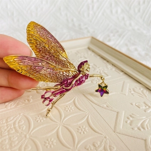 Golden fairy brooch with gradient purple enamel wings holding a colorful star charm