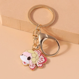 Detail of pink and gold koi fish keychain charm on a minimalist beige background