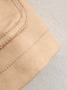 Detailed close-up of double-stitched seams on the camel faux suede jacket fabric