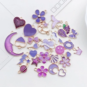 Macro detail of purple enamel charms in heart and moon shapes for DIY jewelry making
