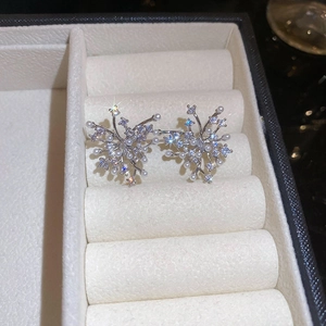 Close-up of snowflake earrings with white pearls and zircons in a velvet jewelry box
