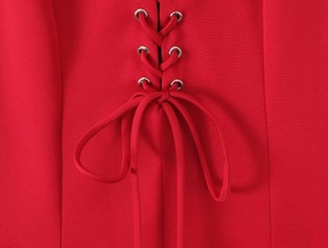 Close-up of red ruffled dress with adjustable lacing and metallic silver eyelets